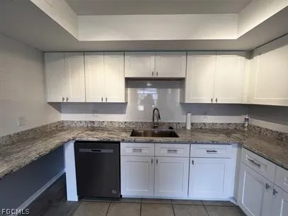 a kitchen with granite countertop a sink and cabinets