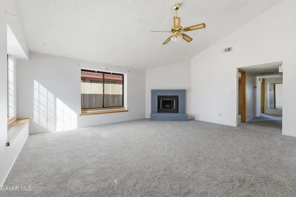 an empty room with fan and windows