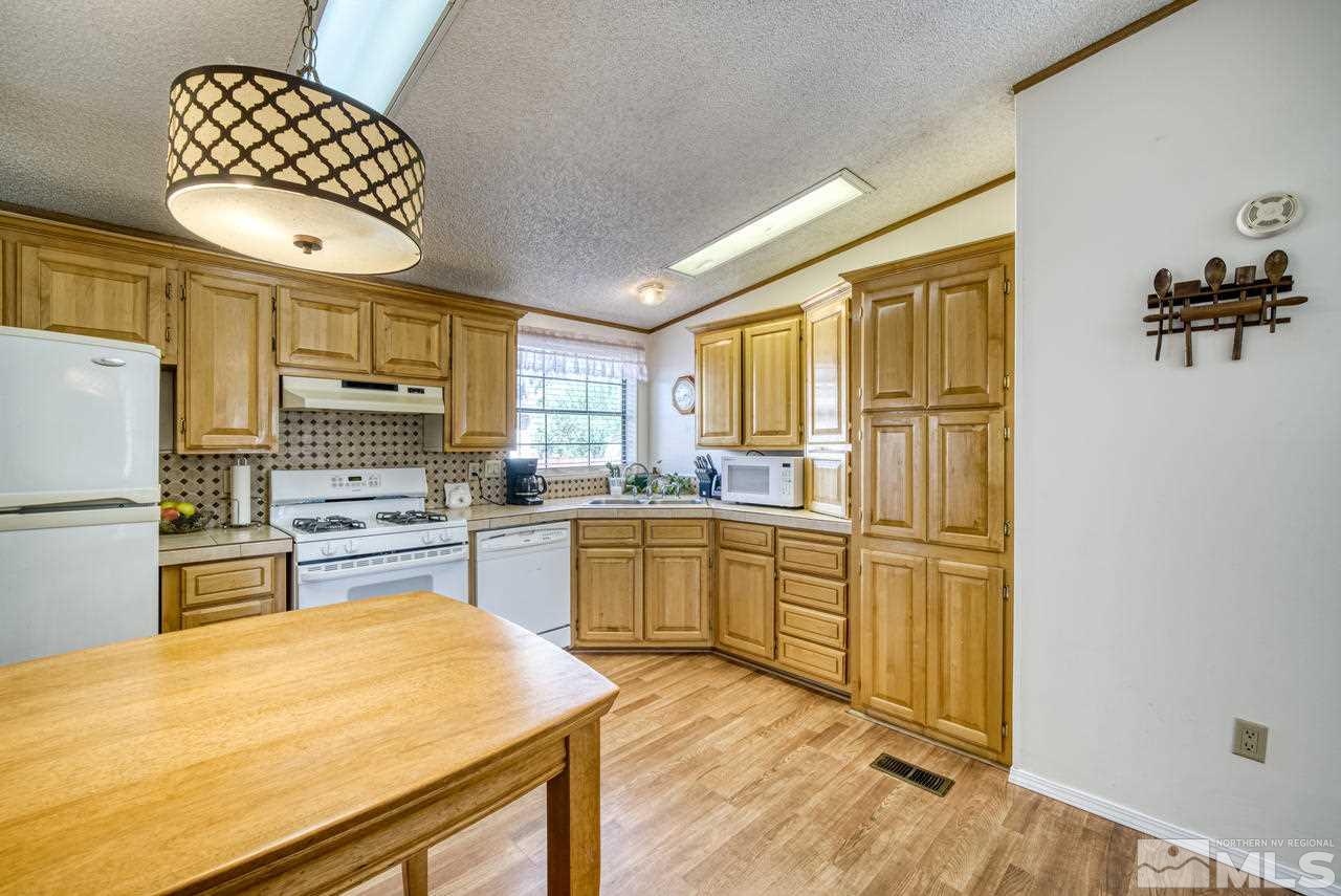 15030 Vega Street Reno, NV 89521 - Photo 10 of 29 a kitchen with stainless steel appliances a refrigerator sink and cabinets