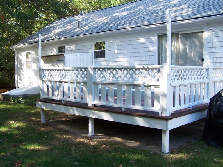 157 Compass Circle Hyannis, MA 02601 - Photo 4 of 21 a view of a wooden bench sitting in back yard of a house