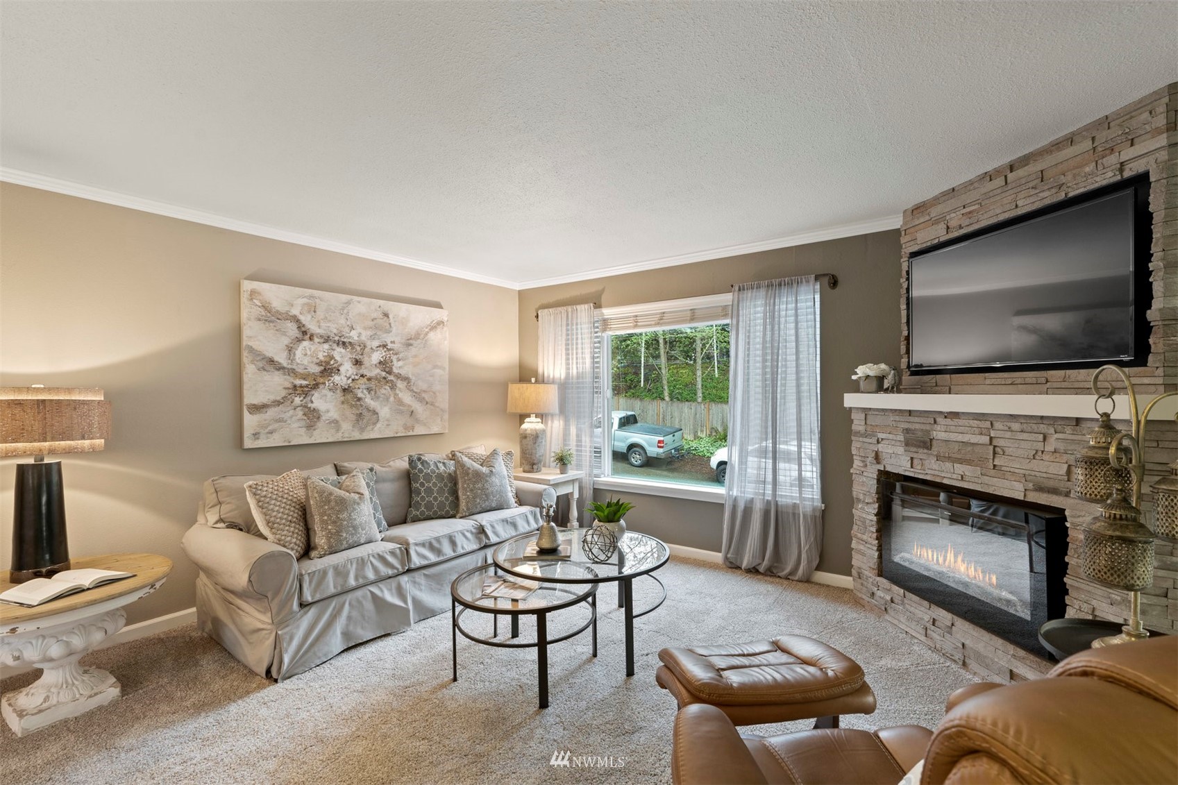8806 Shell Place, Unit 100L Edmonds, WA 98026 - Photo 6 of 25 a living room with furniture a flat screen tv and a fireplace