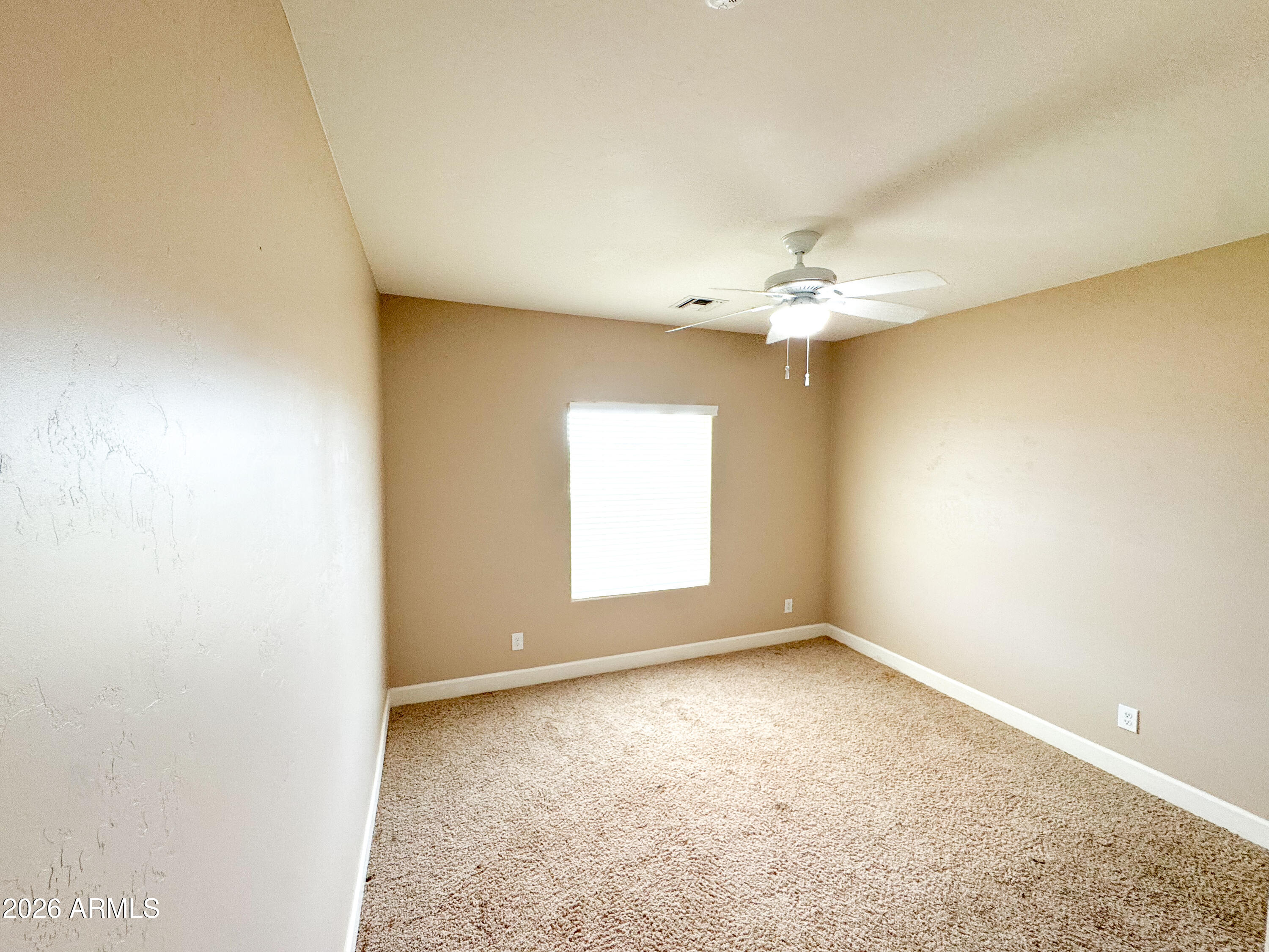 315 North 1720th Street West Pima, AZ 85543 - Photo 18 of 25 an empty room with a chandelier fan and windows