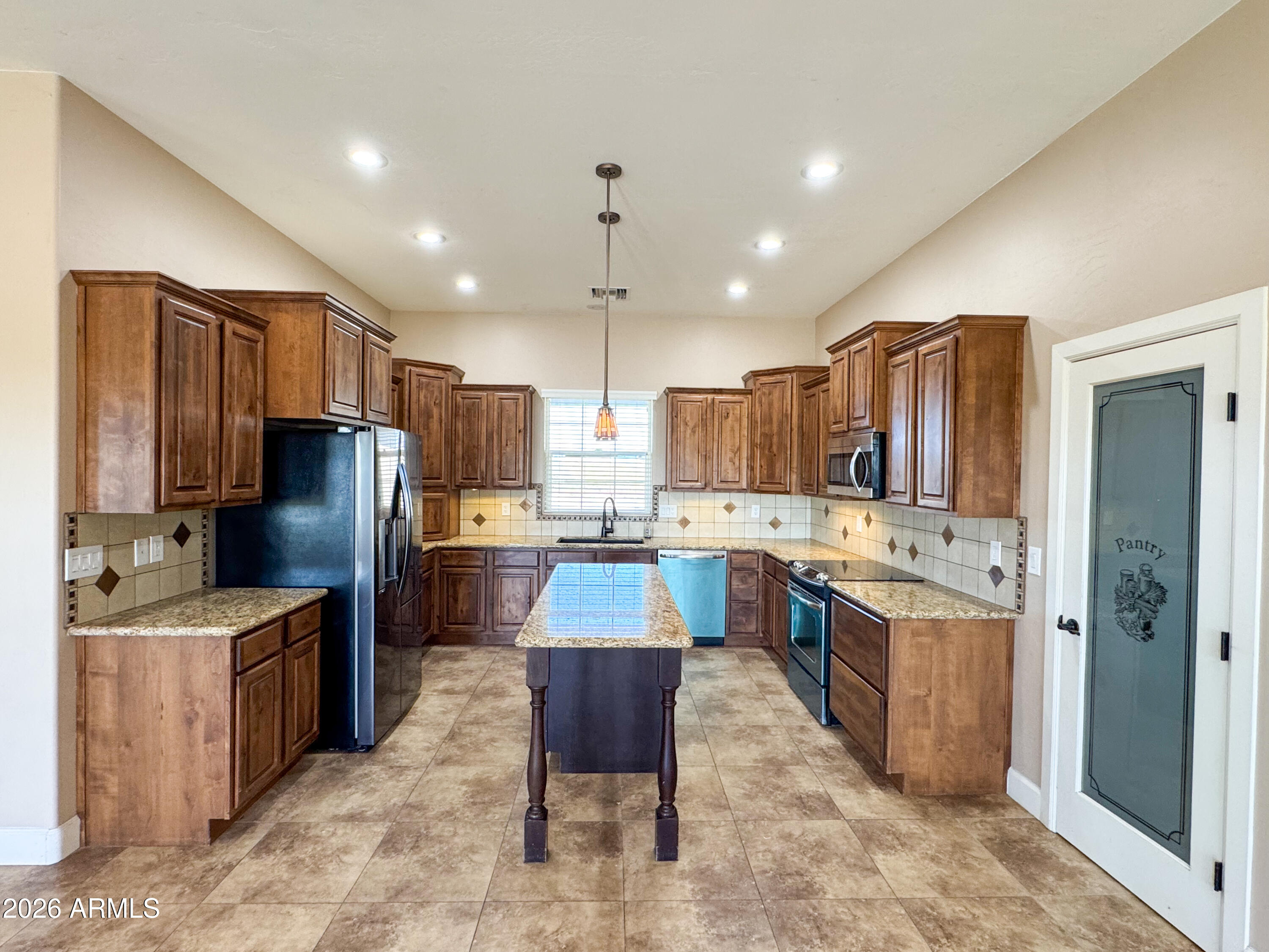 315 North 1720th Street West Pima, AZ 85543 - Photo 7 of 25 a kitchen with stainless steel appliances kitchen island granite countertop a refrigerator stove microwave and sink
