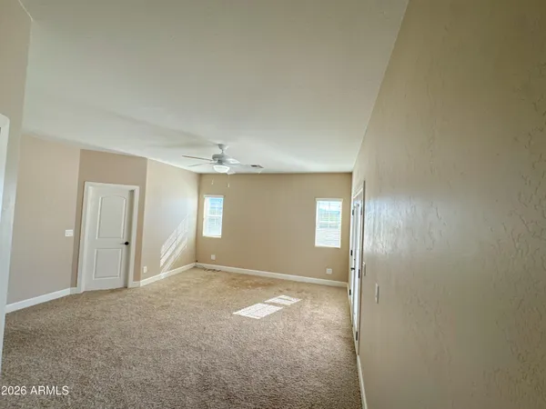 a view of an empty room with window and closet area