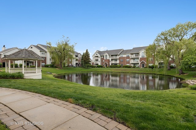 56 Sterling Circle, Unit 102 Wheaton, IL 60189 - Photo 1 of 14 a view of a lake with a house in the background