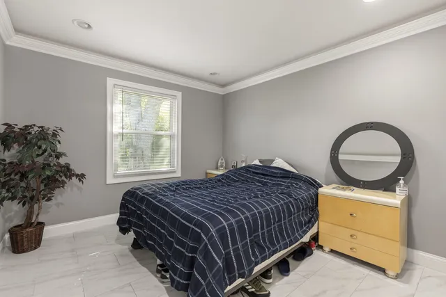 a bedroom with a bed and a potted plant