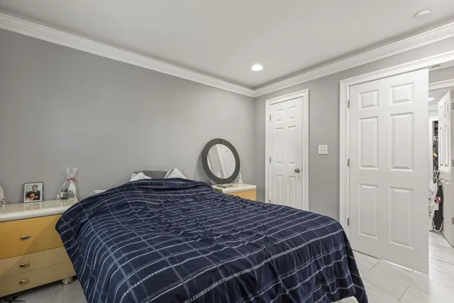 a bed sitting in a bedroom next to a bathroom sink