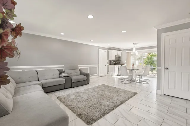 a living room with furniture and view of kitchen