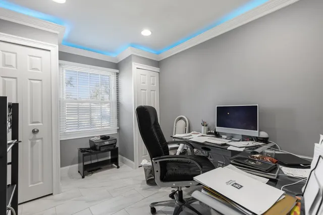 a view of a workspace with furniture and a window