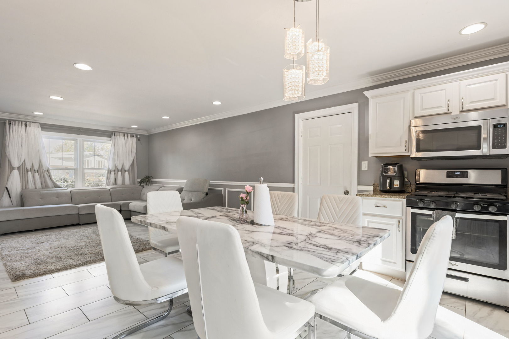 8181 Northway Drive Hanover Park, IL 60133 - Photo 10 of 23 a kitchen with stainless steel appliances granite countertop a stove top oven a sink dishwasher a dining table and chairs with wooden floor