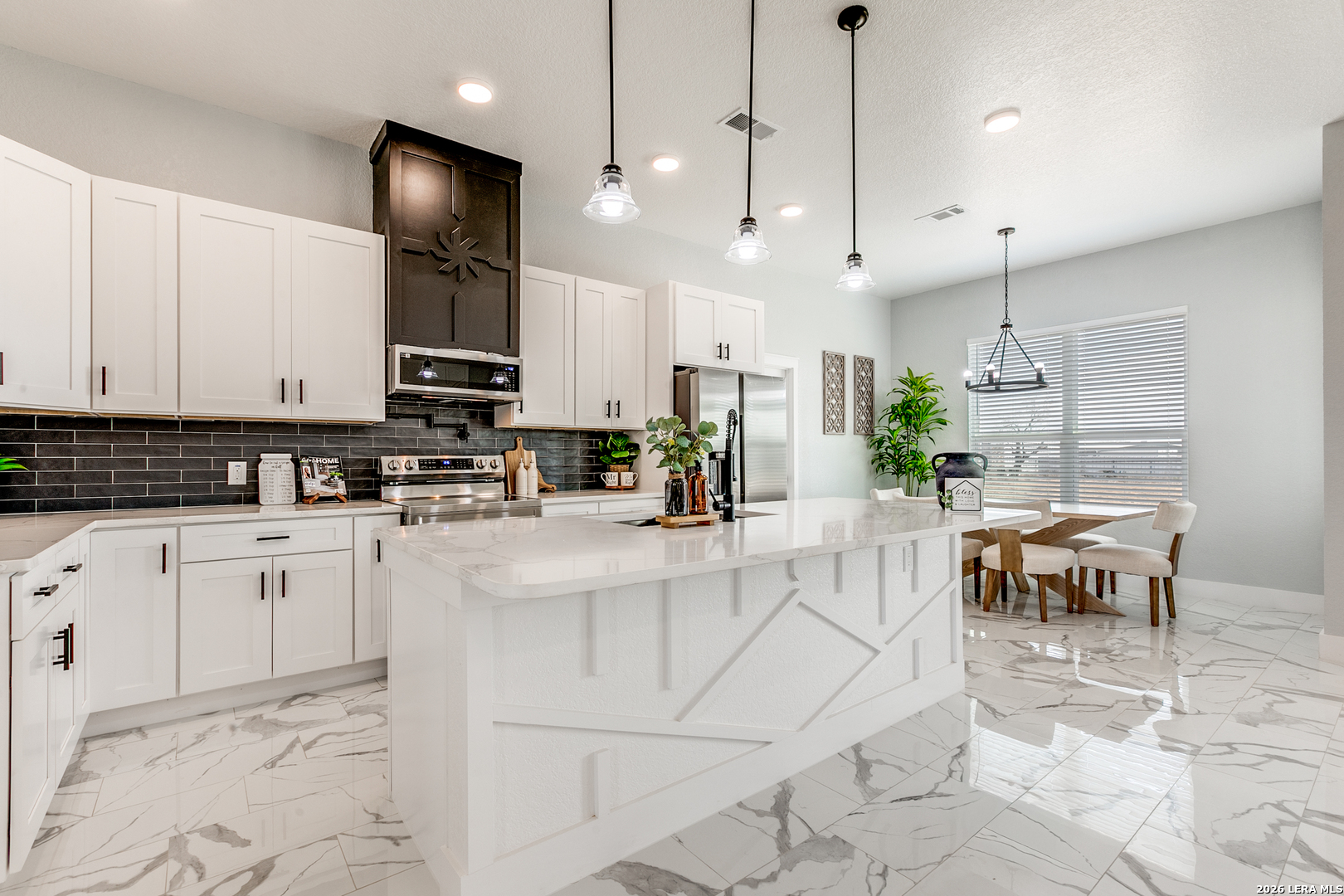 16934 Rancho Atascosa, TX 78002 - Photo 5 of 27 a kitchen with stainless steel appliances kitchen island granite countertop a sink a stove a dining table and chairs