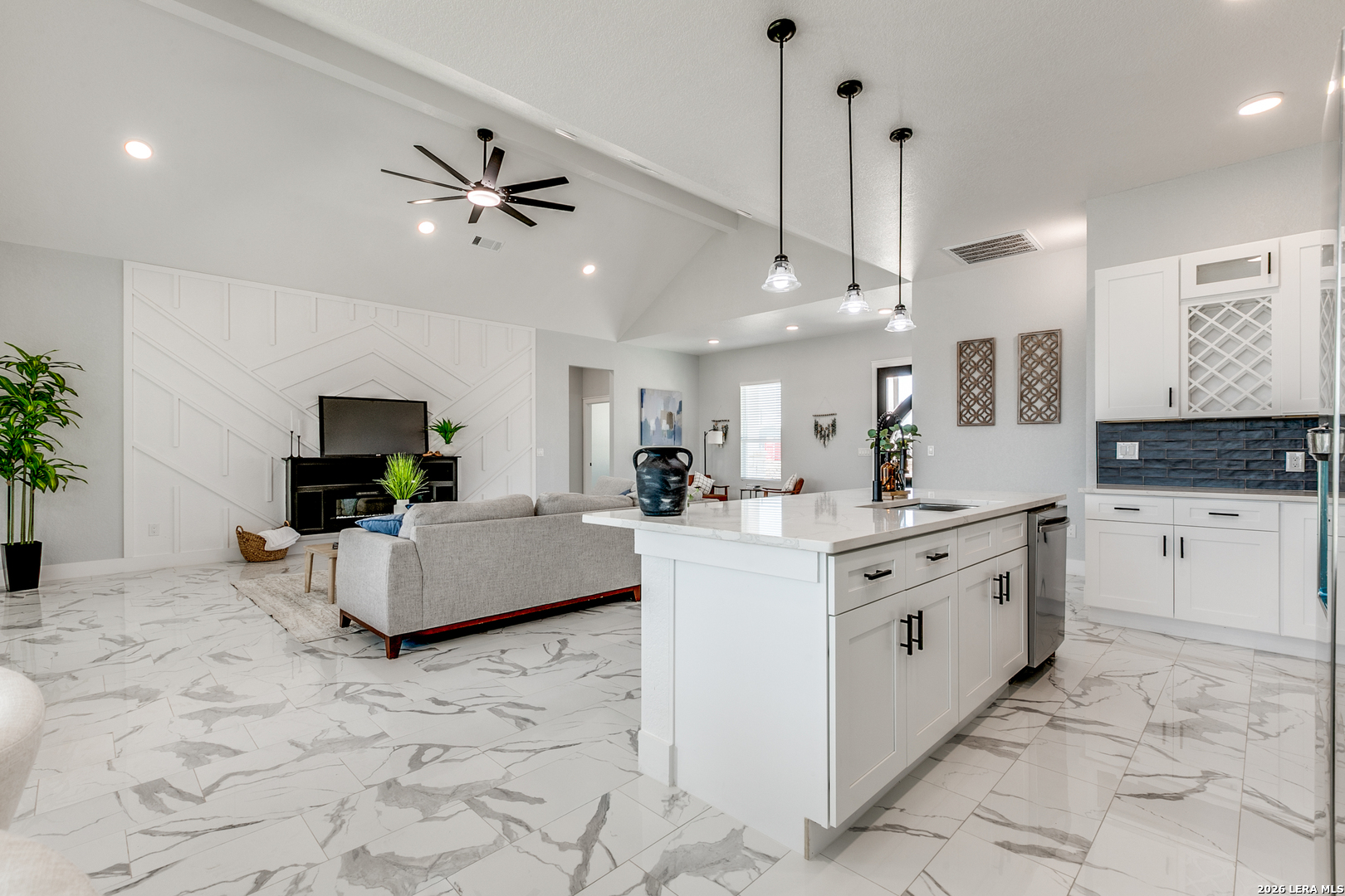 16934 Rancho Atascosa, TX 78002 - Photo 9 of 27 a large white kitchen with kitchen island granite countertop a sink a stove a dining table and chairs