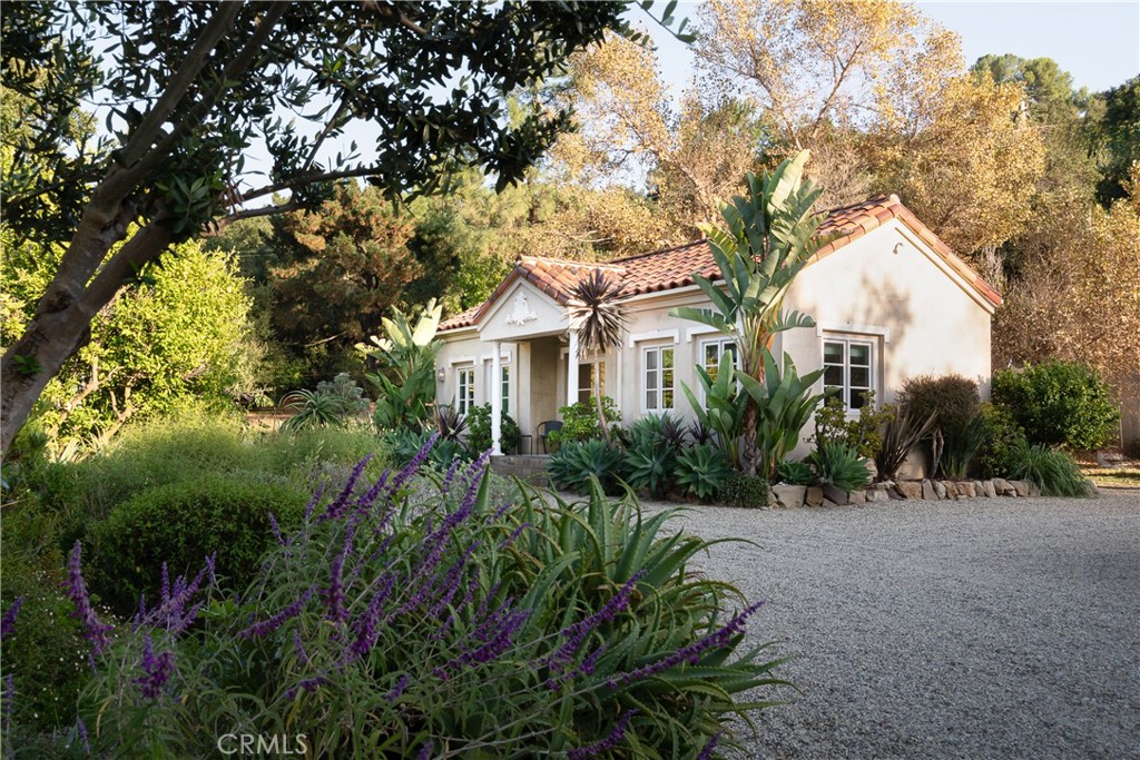21149 Entrada Road Topanga, CA 90290 - Photo 34 of 39 a view of a white house next to a yard and a large tree