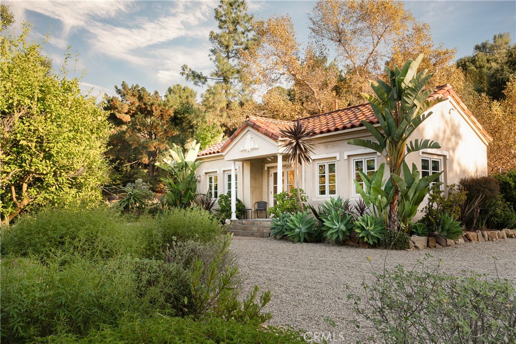 21149 Entrada Road Topanga, CA 90290 - Photo 35 of 39 a view of a white house next to a yard with plants and trees