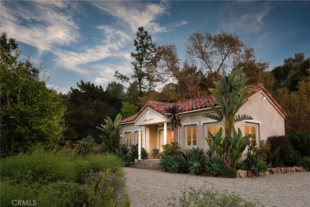 21149 Entrada Road Topanga, CA 90290 - Photo 36 of 39 a white house with a small yard plants and large trees