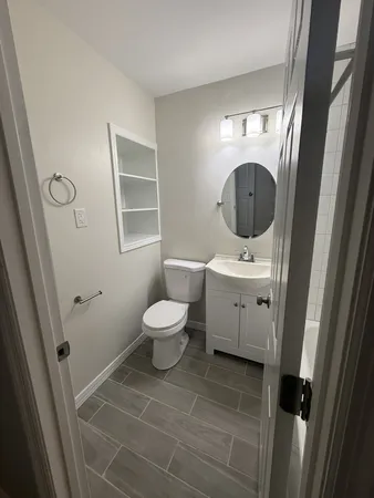 a bathroom with a toilet sink and mirror