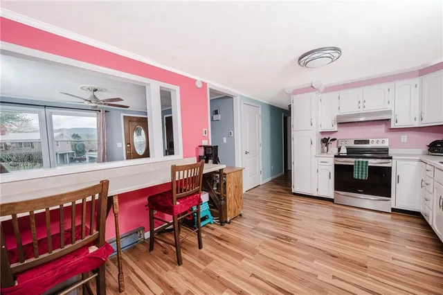 a kitchen with stainless steel appliances kitchen island granite countertop a stove a sink and a microwave