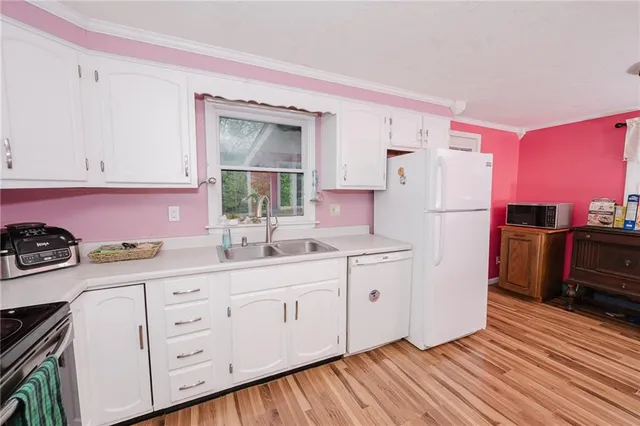 a kitchen with granite countertop a refrigerator sink and cabinets