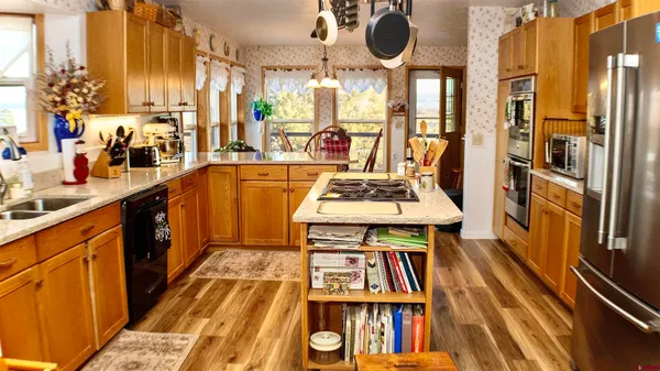 a kitchen with stainless steel appliances granite countertop a stove and a dining table