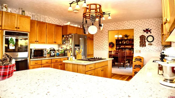 a kitchen with stainless steel appliances kitchen island granite countertop a sink and cabinets