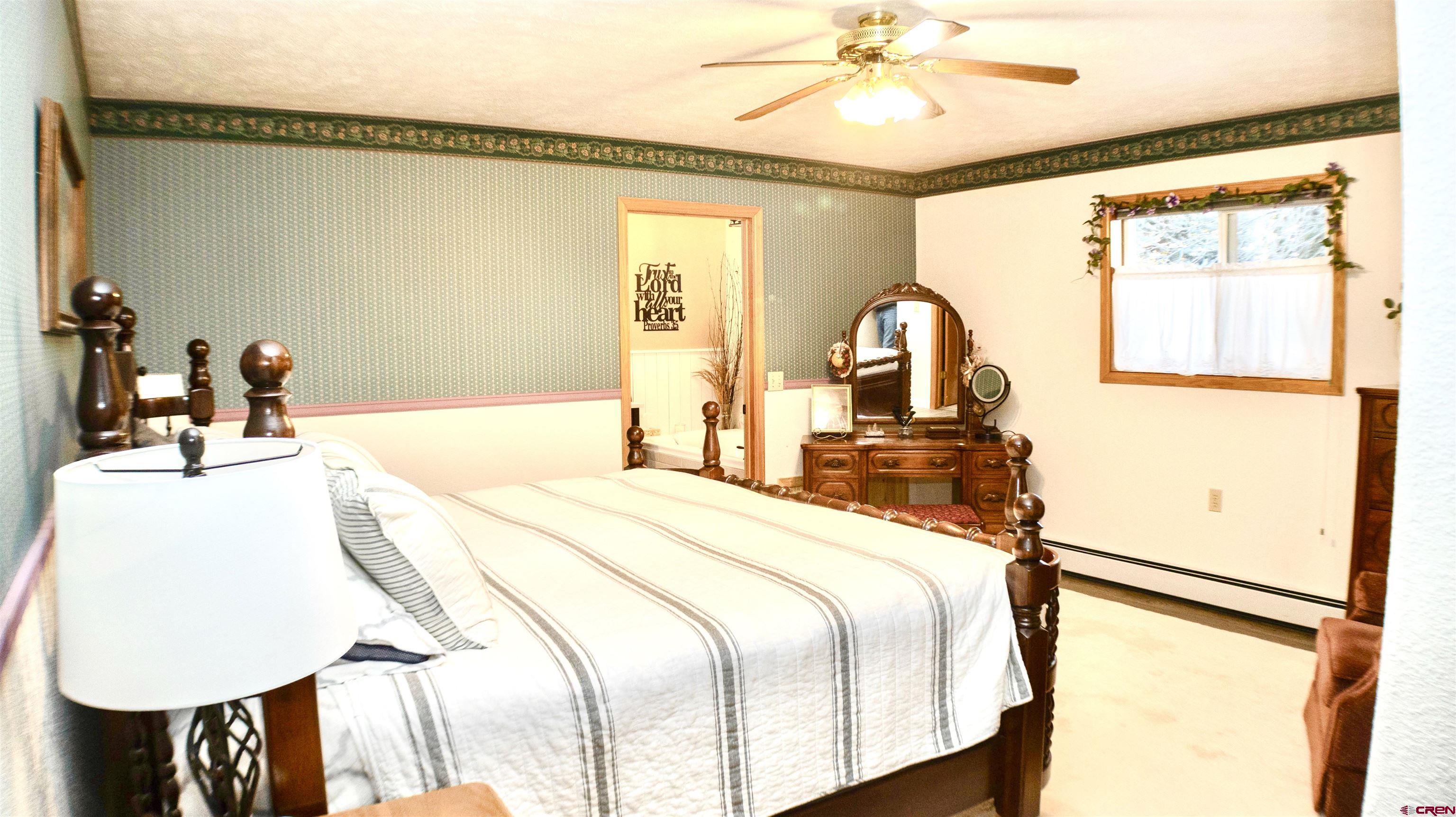 32179 L Road Hotchkiss, CO 81419 - Photo 18 of 45 a bedroom with a bed and a chandelier