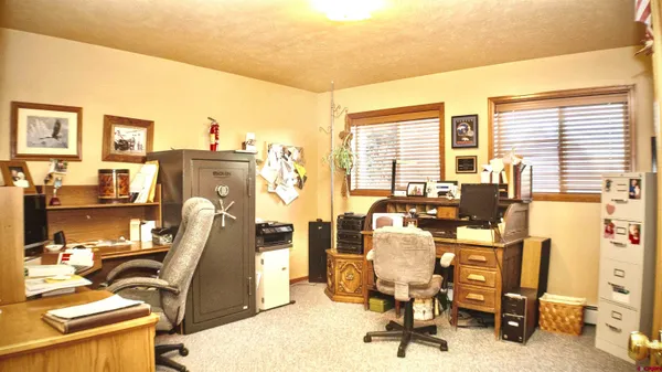 a view of a workspace with furniture and a window