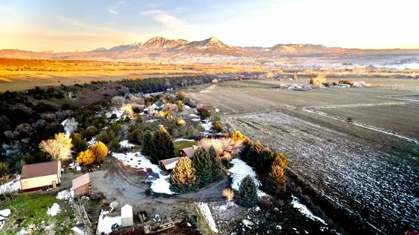 an aerial view of ocean and residential houses with outdoor space