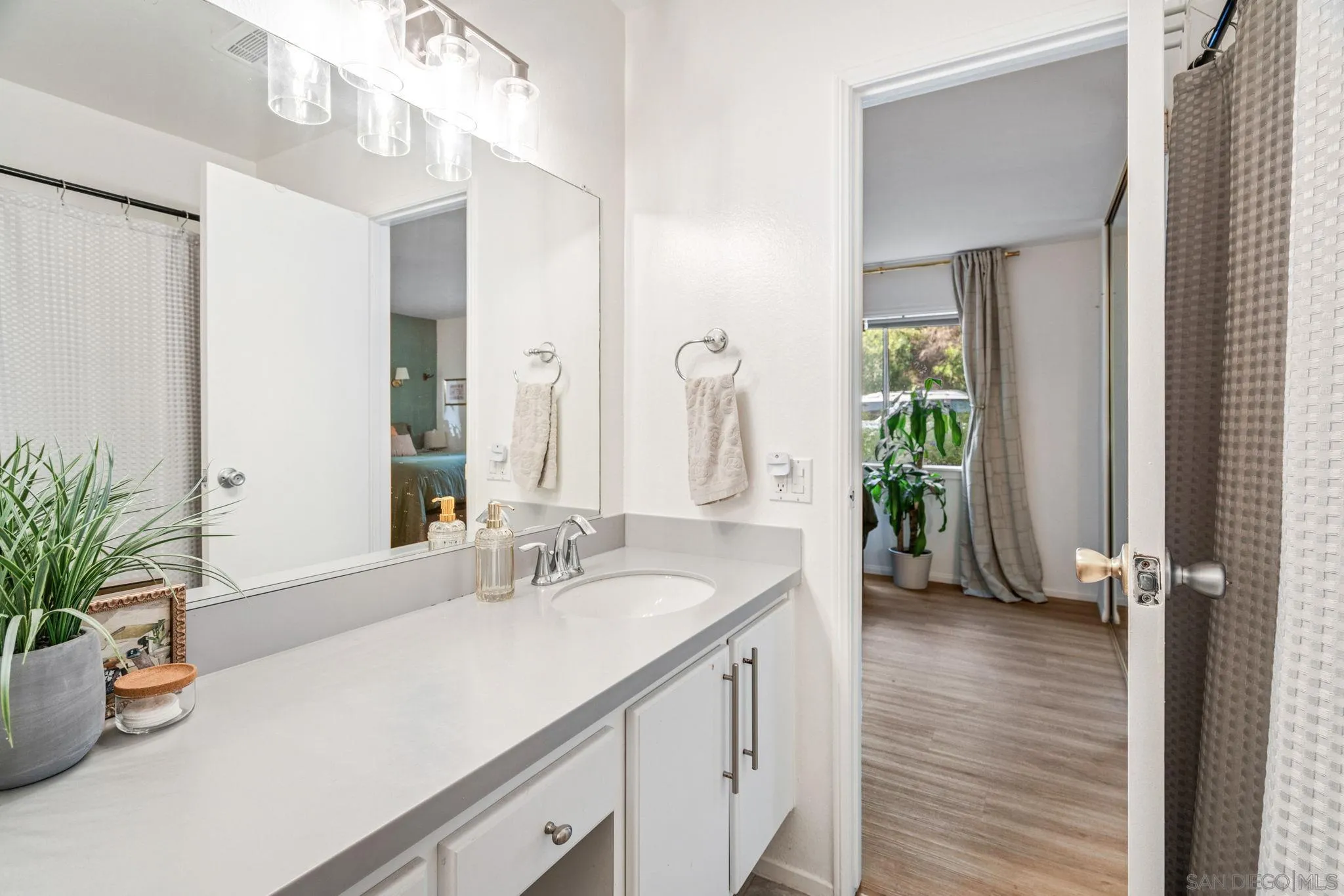 5553 Adobe Falls Road, Unit 1 San Diego, CA 92120 - Photo 16 of 21 a bathroom with a sink a large mirror and shower