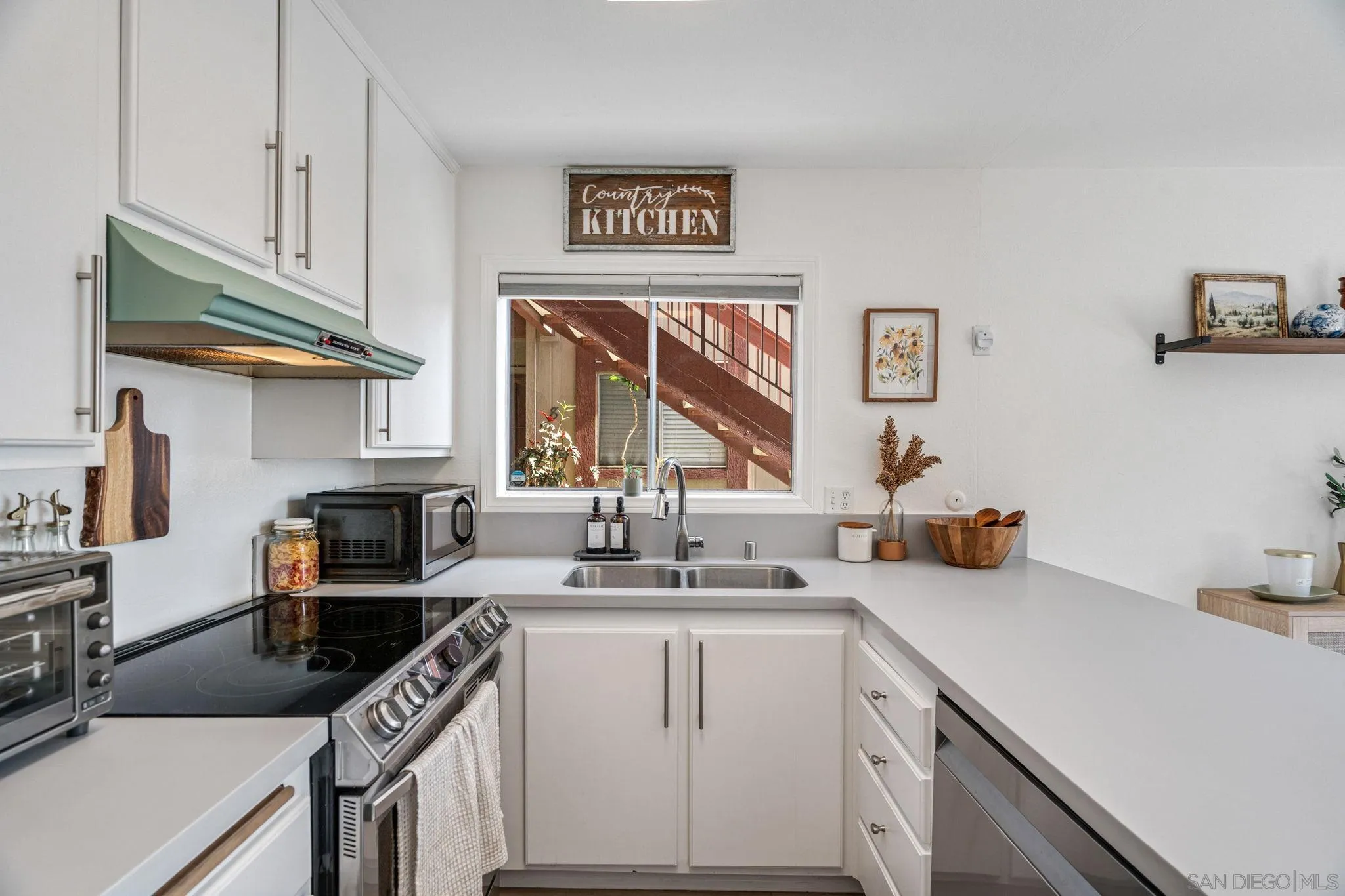 5553 Adobe Falls Road, Unit 1 San Diego, CA 92120 - Photo 5 of 21 a kitchen with a sink stove and cabinets