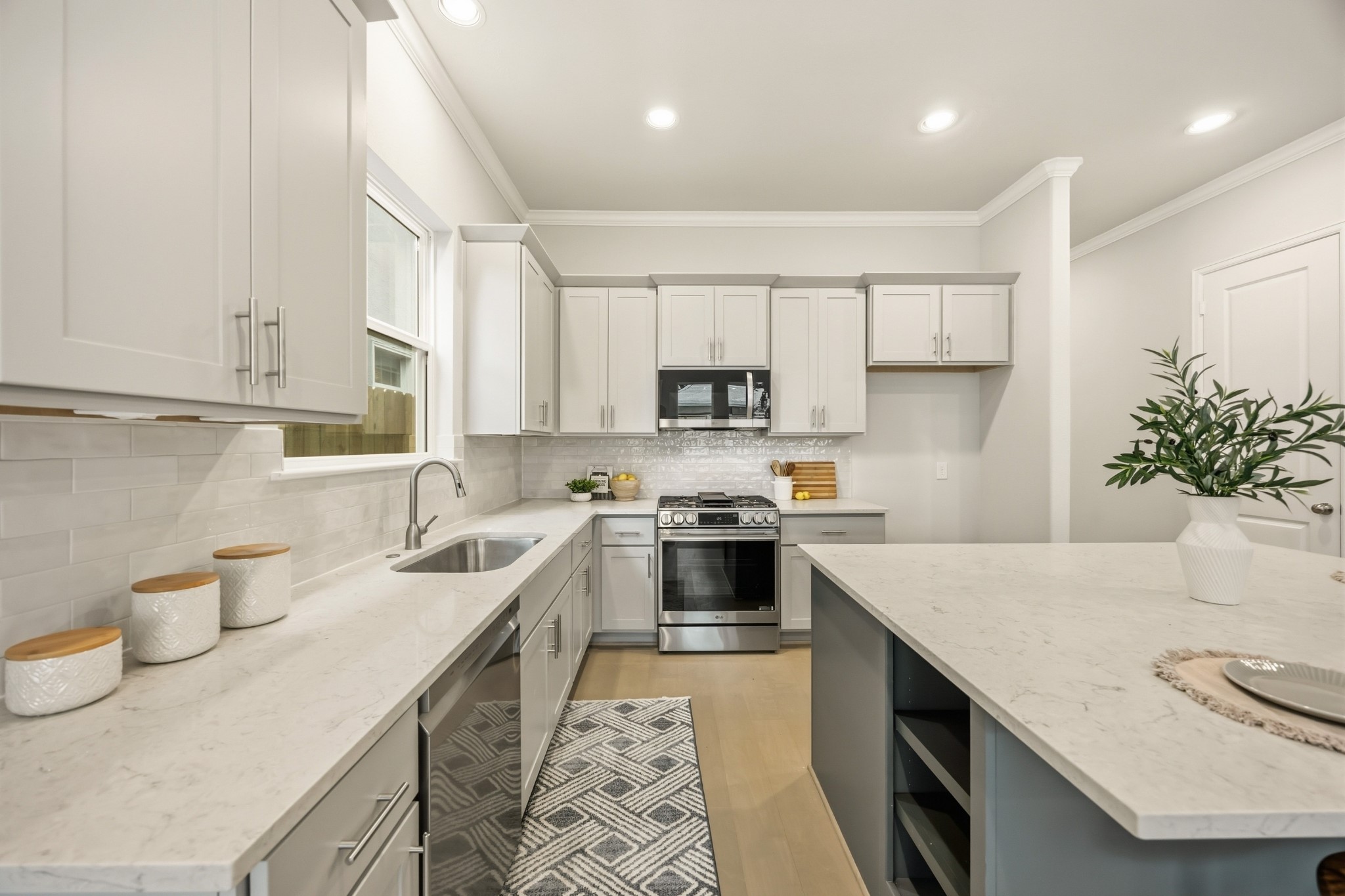 4317 Roseland Street, Unit B Houston, TX 77006 - Photo 2 of 29 Culinary excellence awaits in a kitchen adorned with a large island, abundant quartz countertops, and ample space for two chefs to work together seamlessly. Enjoy the convenience of soft-close drawers and a waste bin pull-out, adding a touch of luxury to your cooking experience.