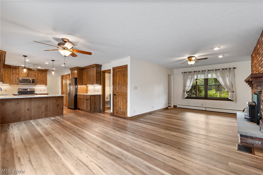 34 Kehner Road Mogadore, OH 44260 - Photo 8 of 40 Expansive wood-finish flooring throughout, complemented by a kitchen with wood cabinetry and a large island
