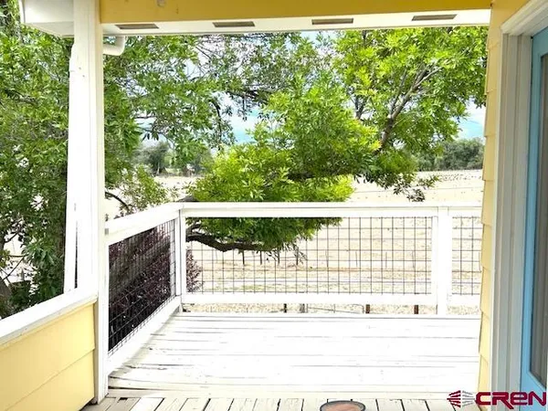 a view of balcony with wooden floor and fence