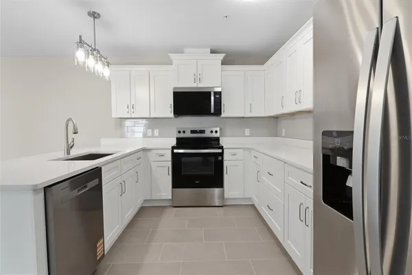 a kitchen with stainless steel appliances a refrigerator sink and white cabinets