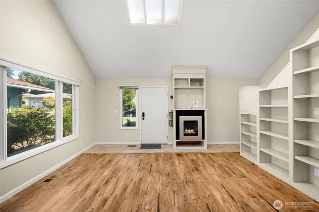 an empty room with window and wooden floor