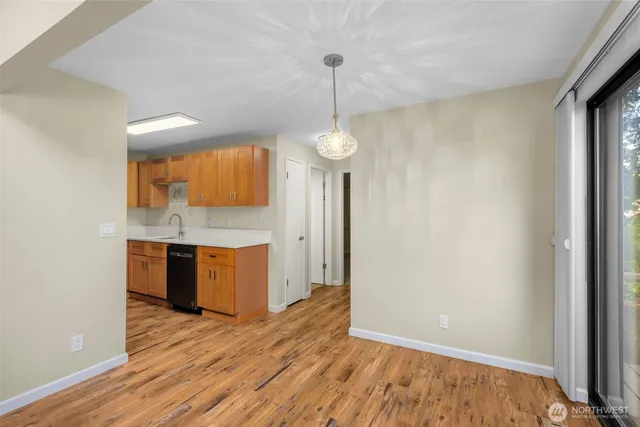 a room with stainless steel appliances granite countertop a sink a refrigerator and a window