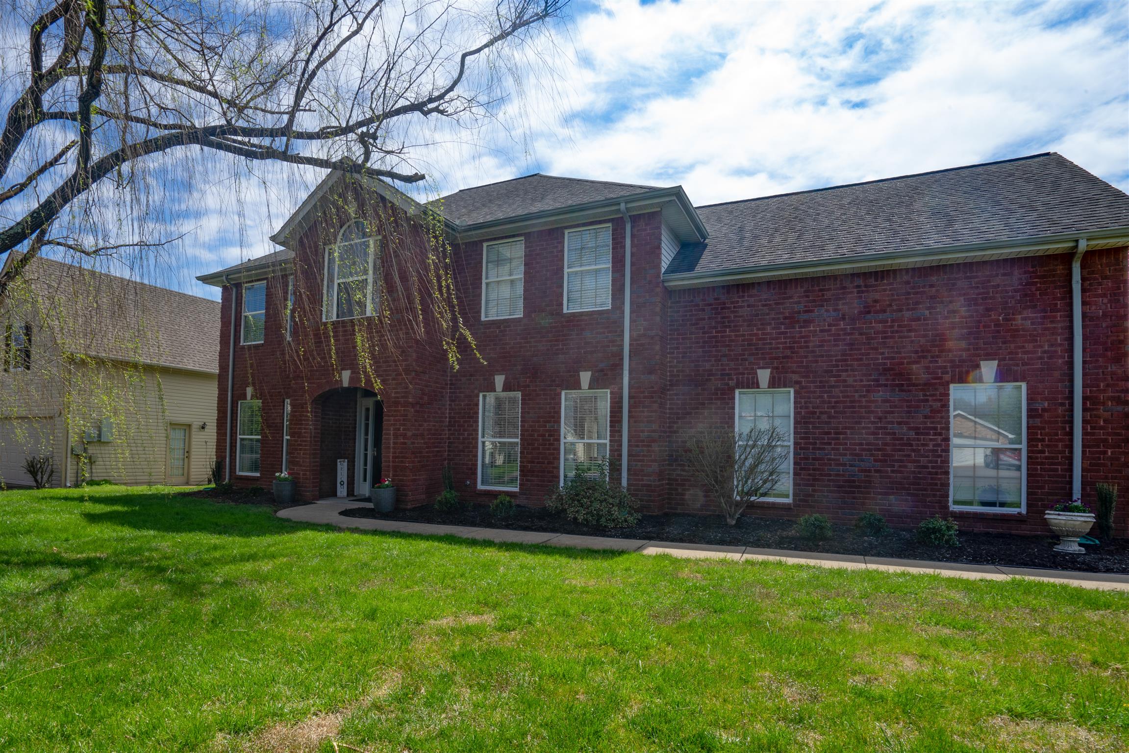 4002 Amber Way Spring Hill, TN 37174 - Photo 1 of 21 a view of a house with brick walls and a yard with a large tree