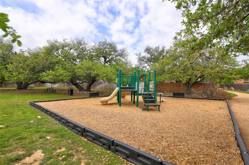 3451 Mayfield Ranch Boulevard, Unit 340 Round Rock, TX 78681 - Photo 12 of 13 A well-maintained community playground awaits, surrounded by mature trees offering ample shade for outdoor enjoyment.