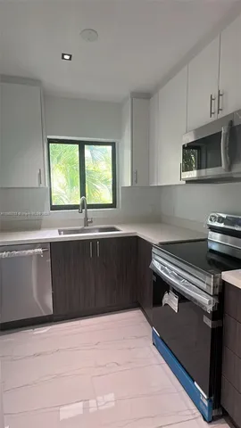 a kitchen with granite countertop a stove a sink and a microwave