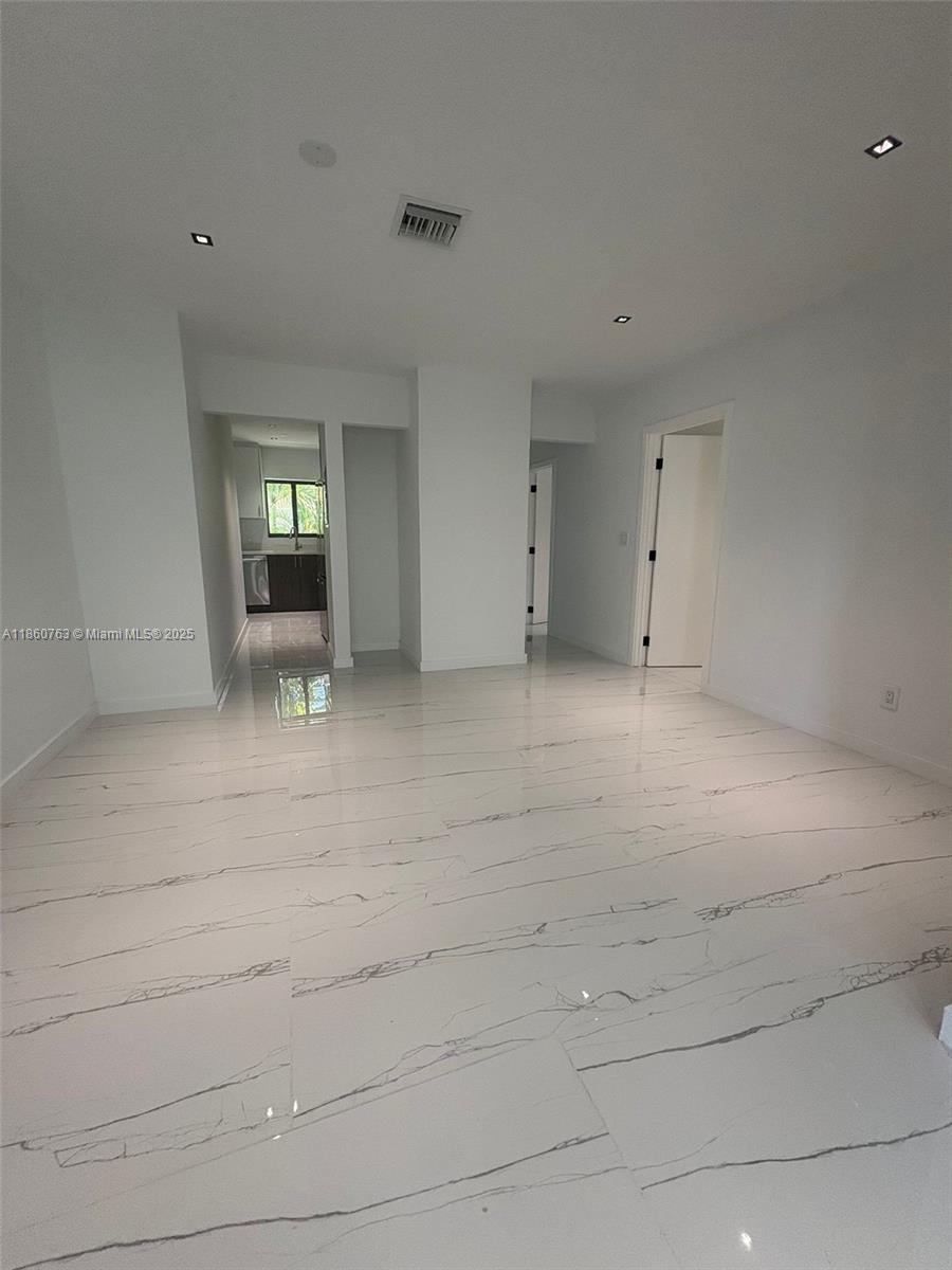 1155 102nd Street, Unit 7 Bay Harbor Islands, FL 33154 - Photo 8 of 10 a view of an empty room with wooden floor and a window
