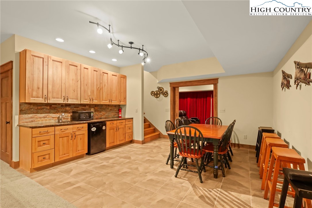 138 South Camp Road, Unit 103 Boone, NC 28607 - Photo 30 of 50 a kitchen with stainless steel appliances granite countertop a stove top oven a sink a dining table and chairs with wooden floor