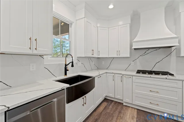 a kitchen with a stove and a wooden floor