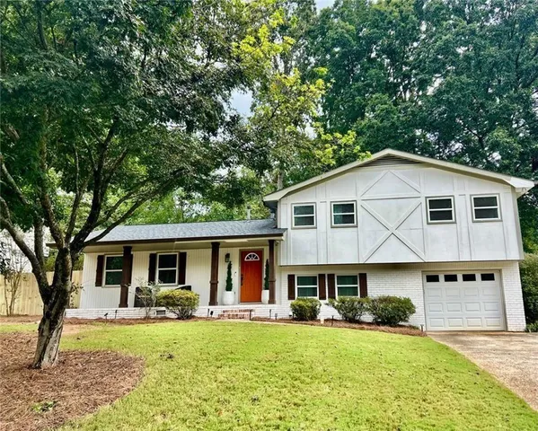 a view of a house with a yard patio and a small yard