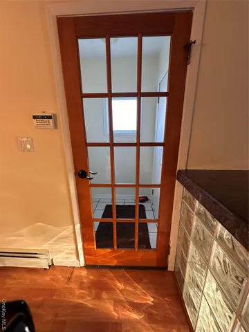 a view of an empty room with wooden floor and windows