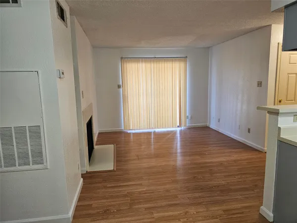 a view of a room with wooden floor and window