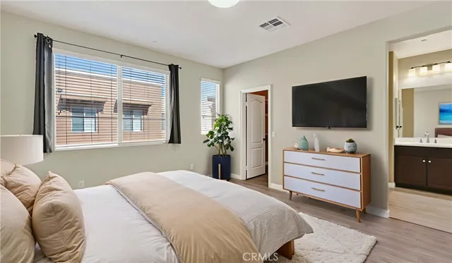 a bedroom with a large bed and a flat screen tv