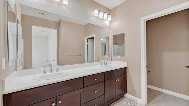 a bathroom with double vanity sinks and a mirror