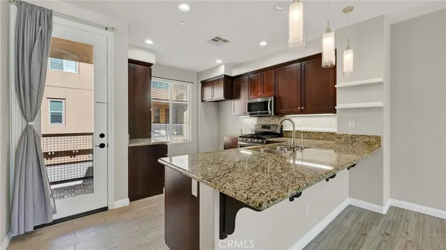 a kitchen with kitchen island granite countertop a sink stove and refrigerator