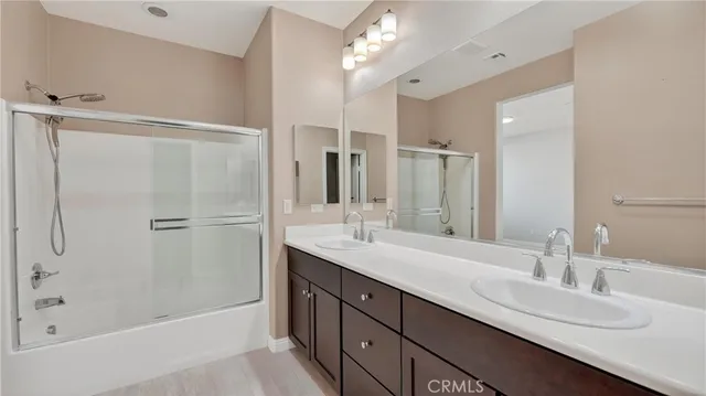 a bathroom with a double vanity sink mirror and shower