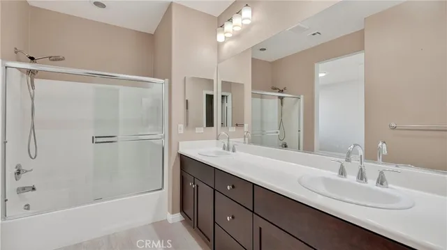 a bathroom with a double vanity sink mirror double and shower