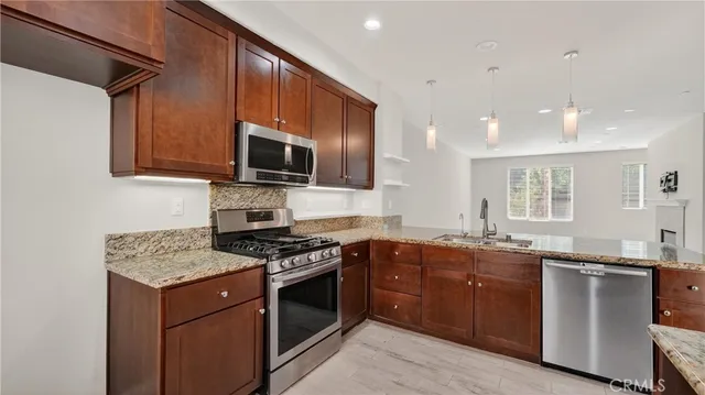 a kitchen with granite countertop a sink and steel appliances